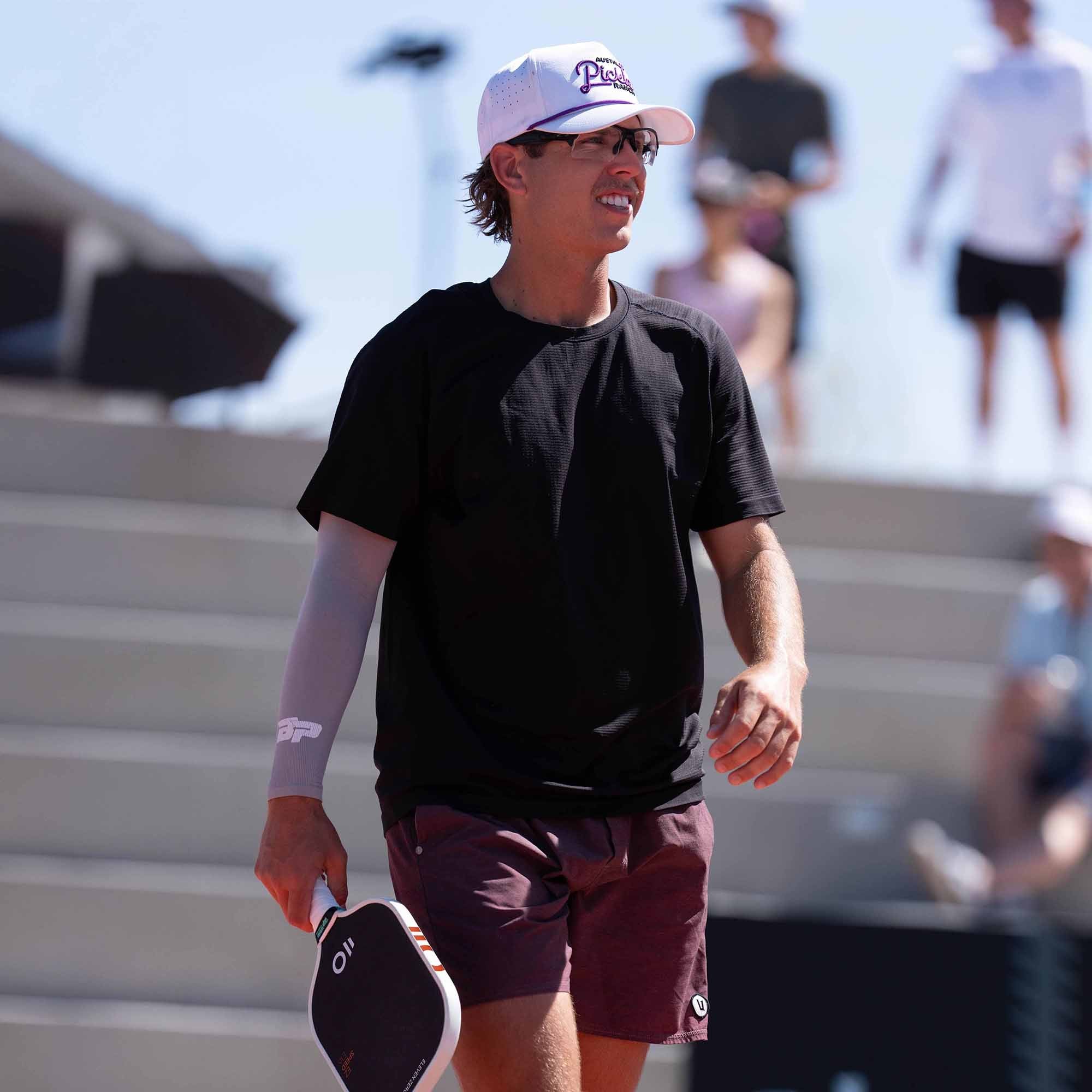 Austin Bricker walking on court with an Eleven Zero paddle during tournament play
