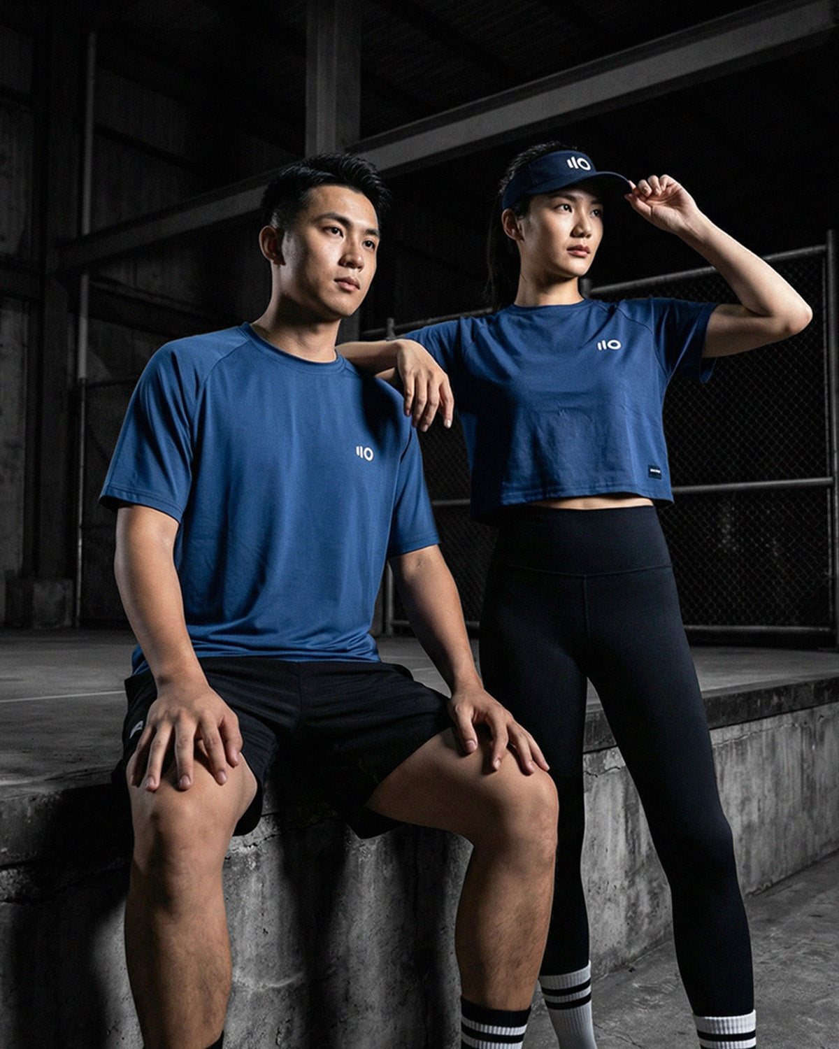 Two pickleball players in Eleven Zero apparel inside an indoor court facility