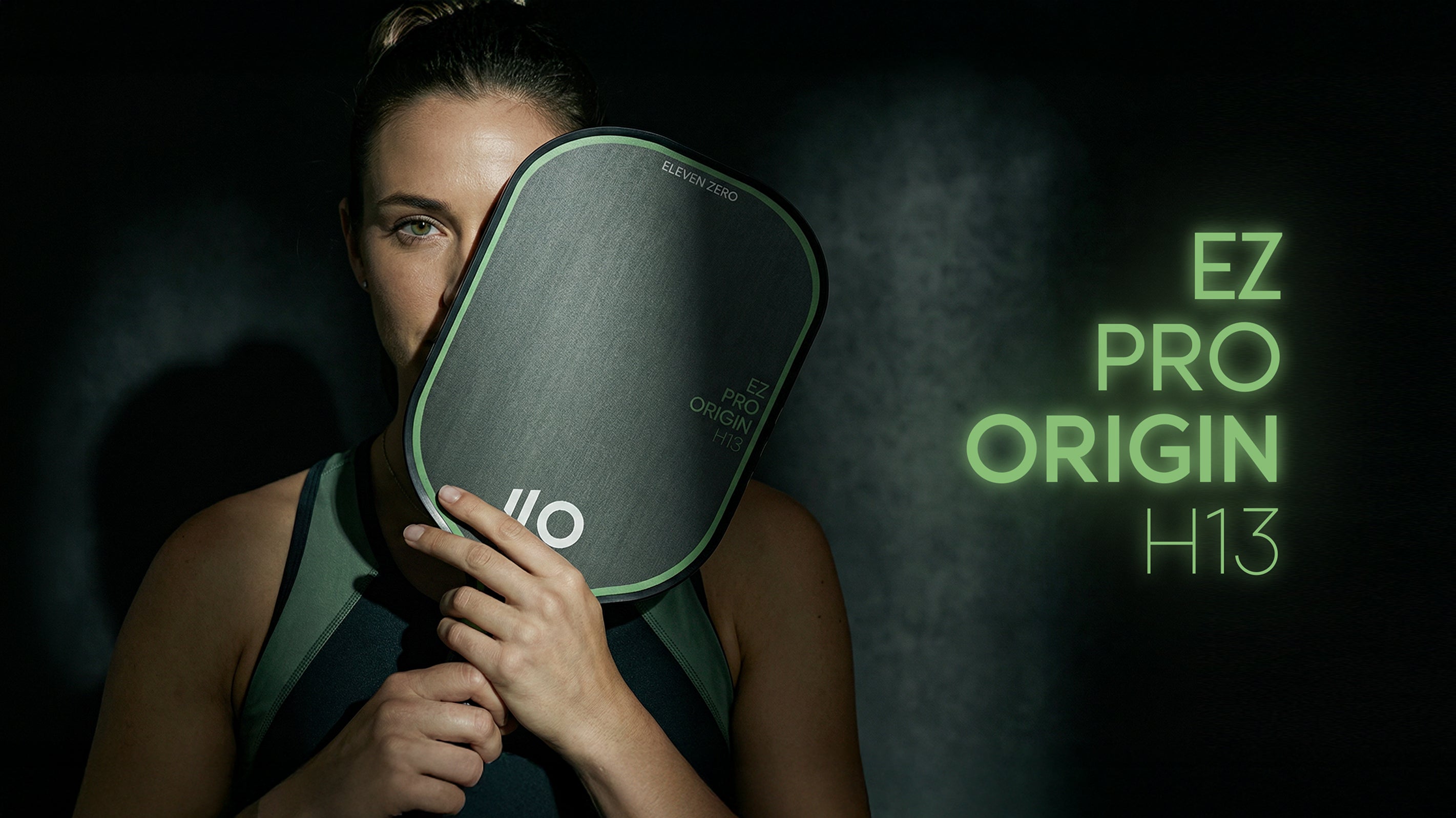 Eleven Zero Sports pickleball paddles in black carbon and Kevlar resting on a blue pickleball court surface.