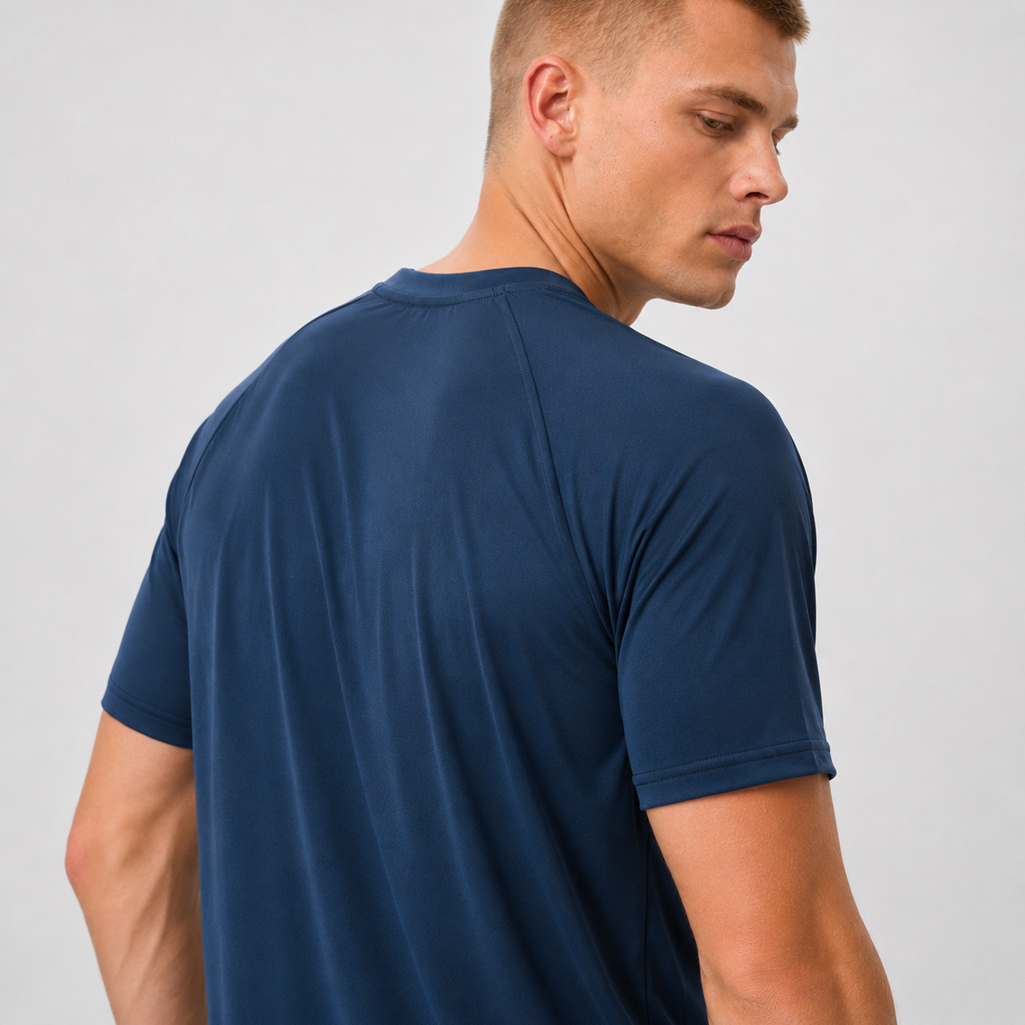 Man wearing a navy blue t-shirt against a plain background