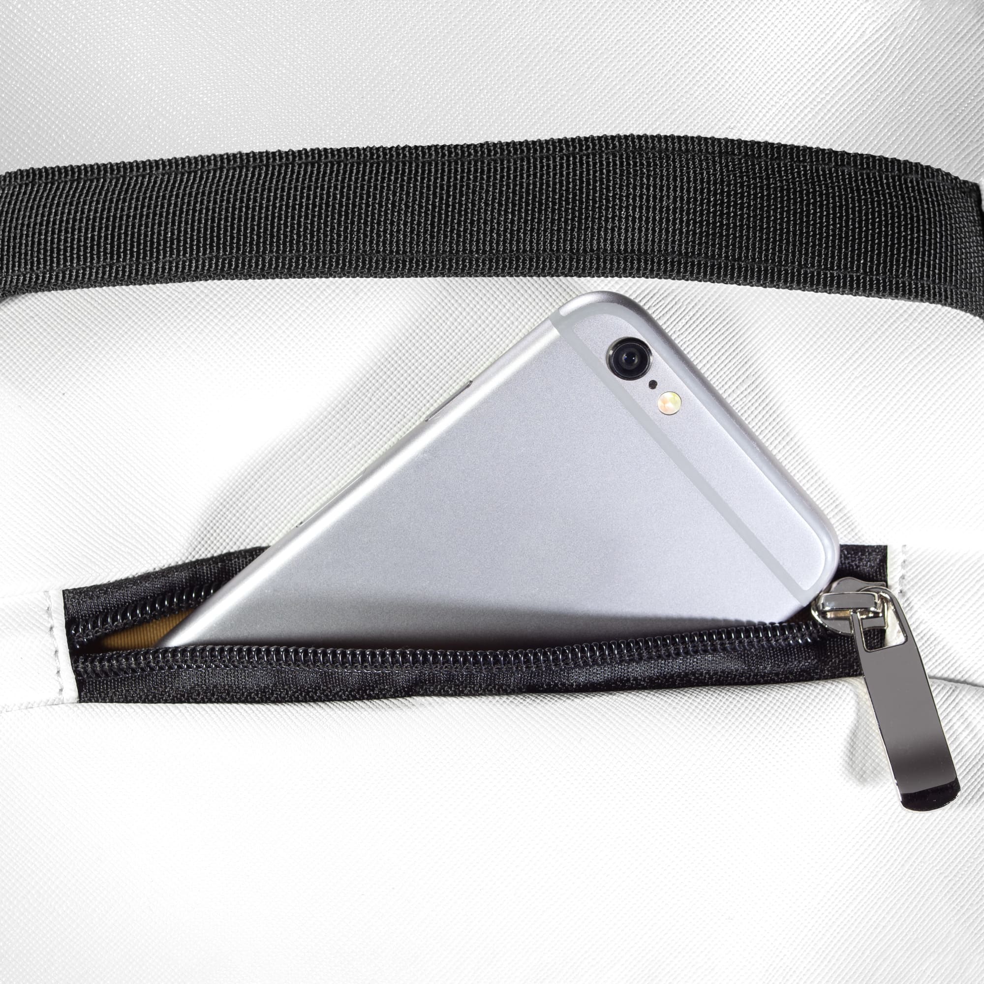 Zippered pocket on top of backpack holding a smartphone, showing convenient access design.