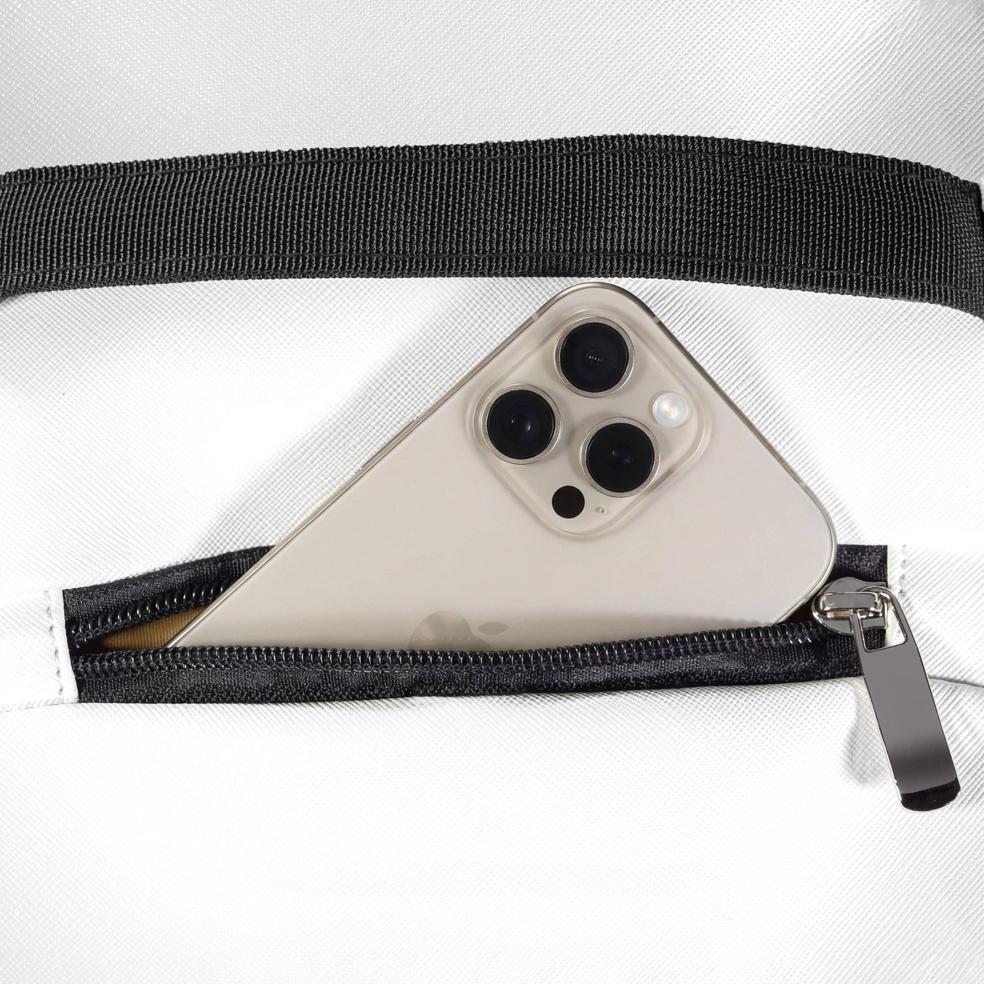 Zippered pocket on top of backpack holding a smartphone, showing convenient access design.