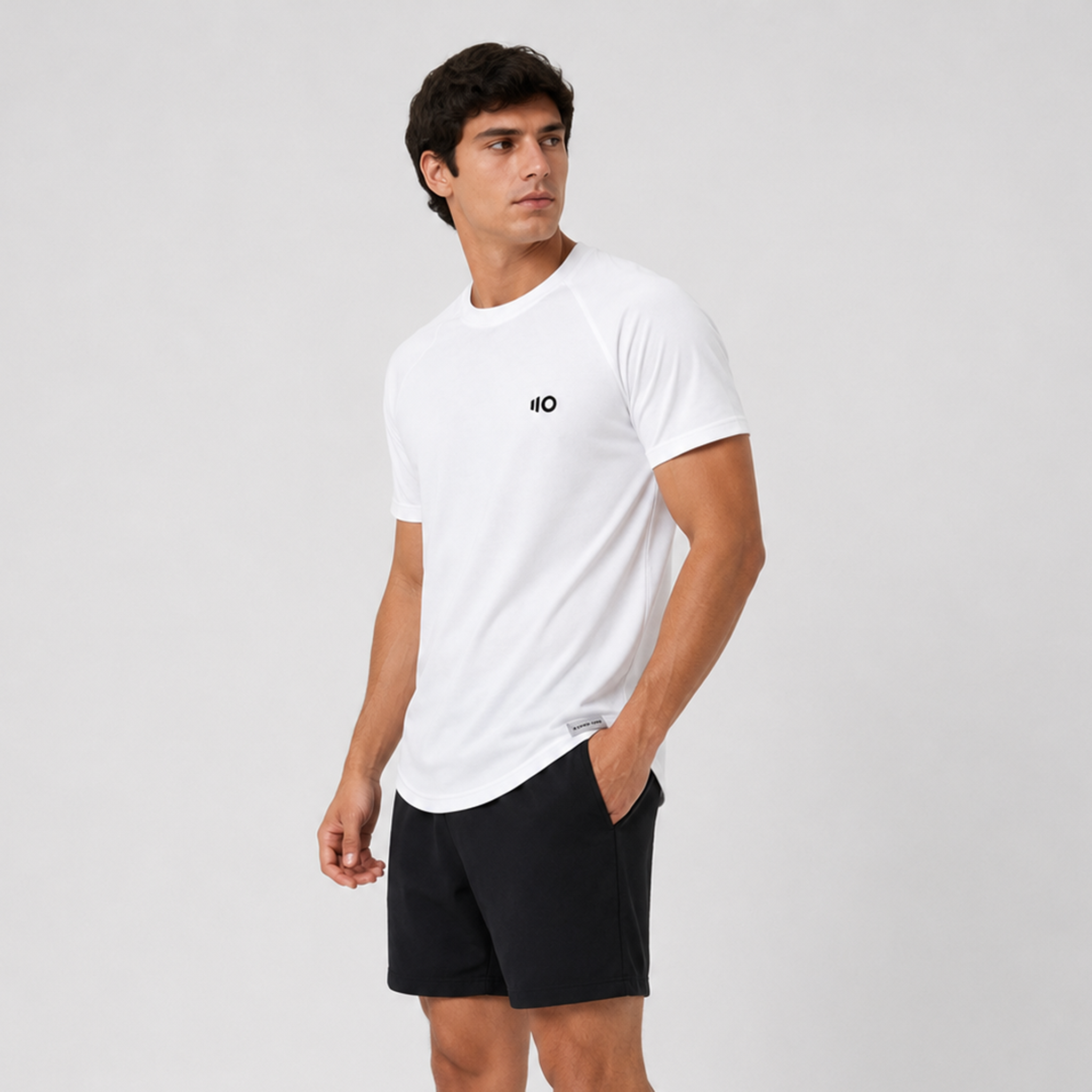 Man wearing a white t-shirt and shorts with a logo on a light gray background