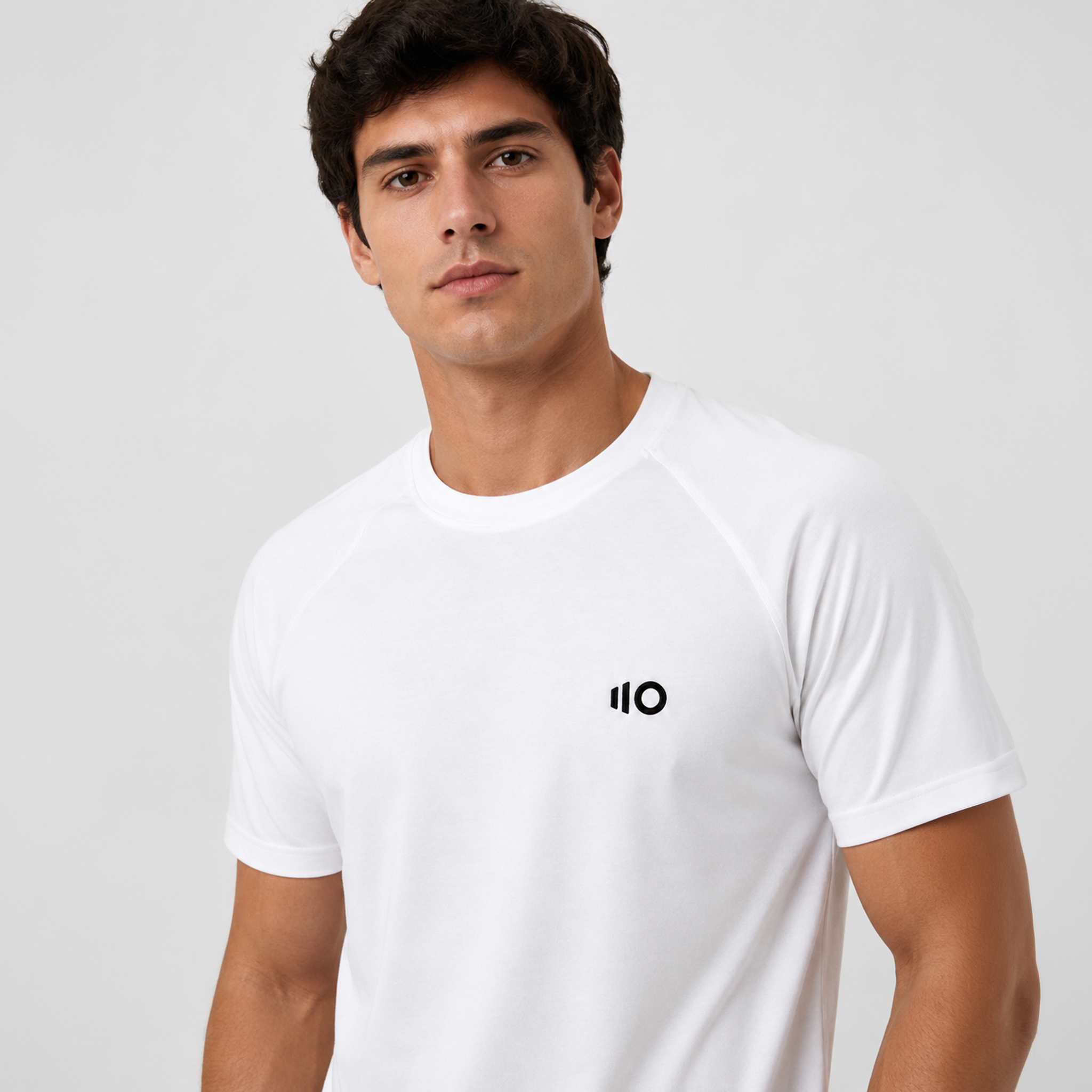 Man wearing a white t-shirt with a logo on a gray background