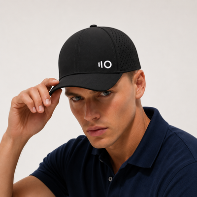 Man wearing a black cap with Eleven Zero logo on a plain background