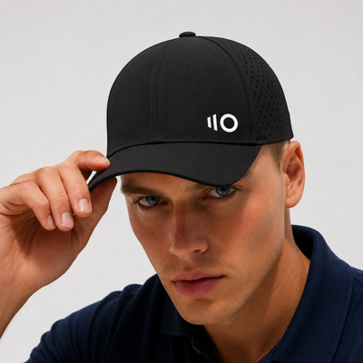 Man wearing a black cap with a logo on a gray background