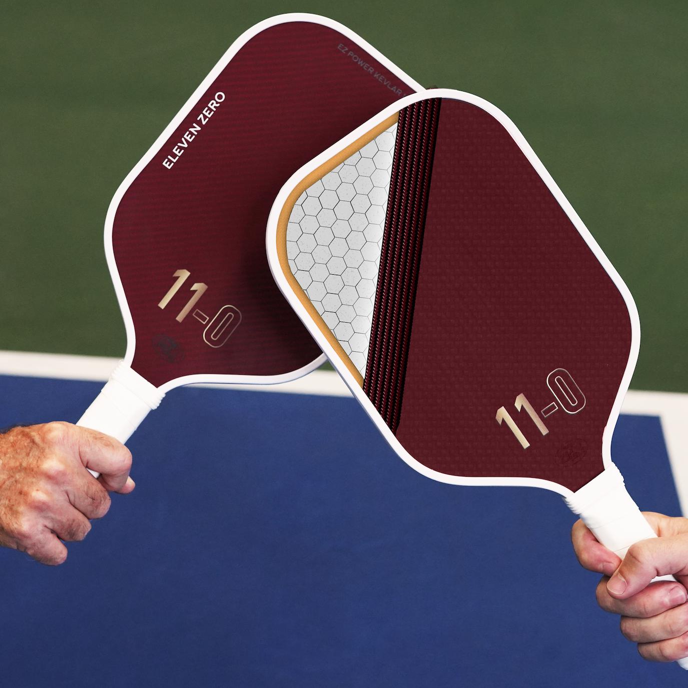 Two maroon Eleven Zero Kevlar® paddles showing internal construction layers, including a honeycomb core, EVA foam edge, and durable surface.
