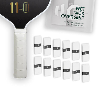 Twelve white Eleven Zero Wet Tack Overgrip strips arranged in rows beside the paddle handle and product packaging.