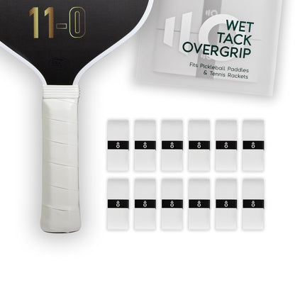 Twelve white Eleven Zero Wet Tack Overgrip strips neatly arranged beside the paddle handle and overgrip packaging.