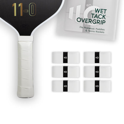 Six white Eleven Zero Wet Tack Overgrip strips arranged next to a pickleball paddle handle and packaging.