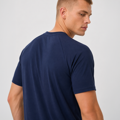 Man wearing a navy blue t-shirt against a plain background