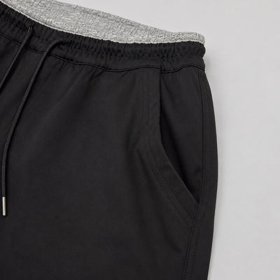 Black pants with a gray waistband on a light gray background