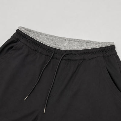 Black shorts with gray waistband on a light gray background