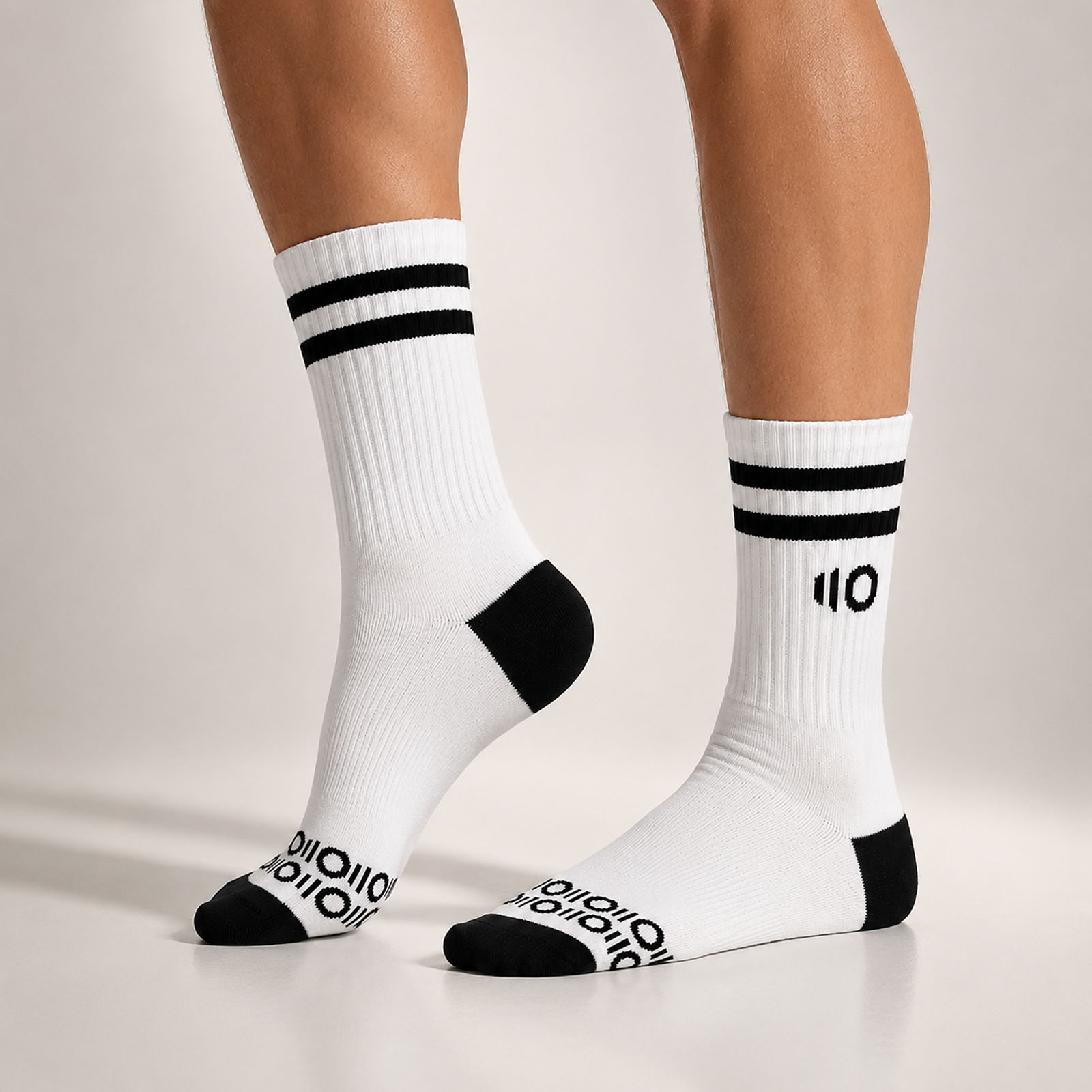 White socks with black stripes and Eleven Zero logo on a neutral background