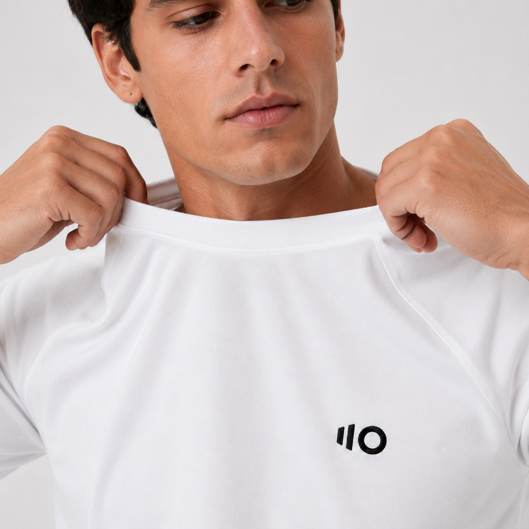 Man wearing a white t-shirt and shorts set with a logo on a gray background