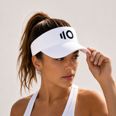 Woman wearing a white visor with Eleven Zero logo on a plain background