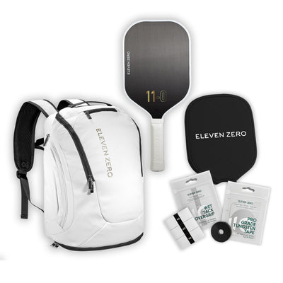 White Eleven Zero pickleball backpack shown with carbon paddle, paddle cover, overgrips, and tungsten tape.