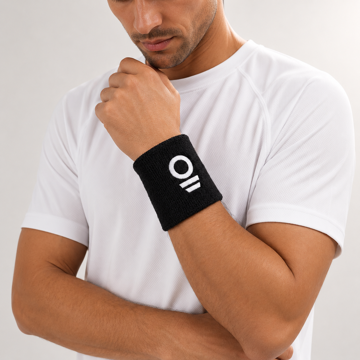 Man wearing a black wristband with Eleven Zero logo on his wrist against a white background